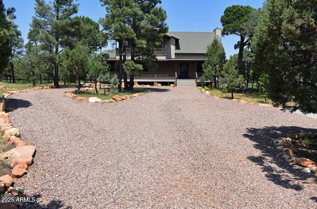 view of front of home with covered porch and gravel driveway