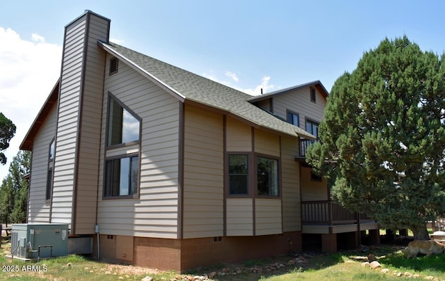 view of home's exterior featuring crawl space, a shingled roof, and a chimney
