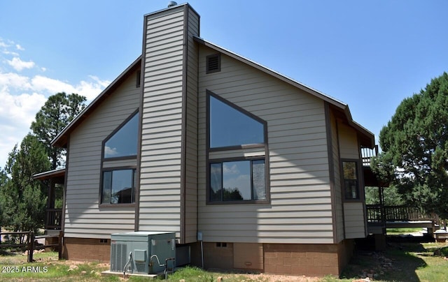 view of home's exterior featuring crawl space, a deck, and a chimney