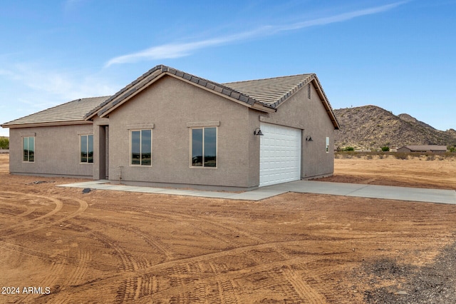 rear view of property featuring a mountain view and a garage