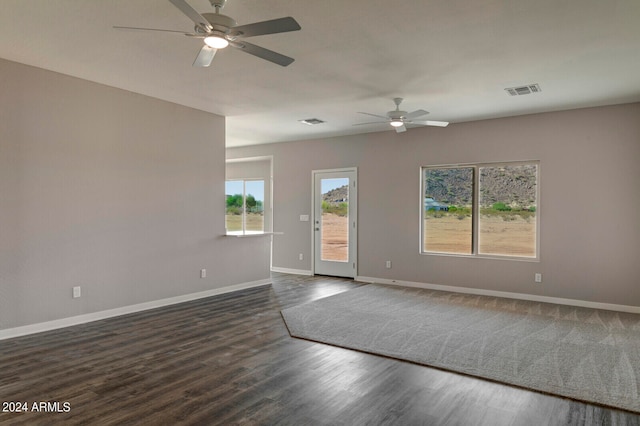 spare room featuring dark wood-type flooring and ceiling fan