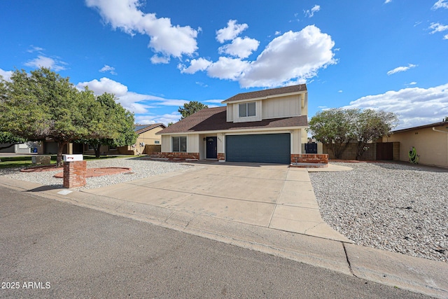 traditional-style home featuring a garage, fence, concrete driveway, and brick siding