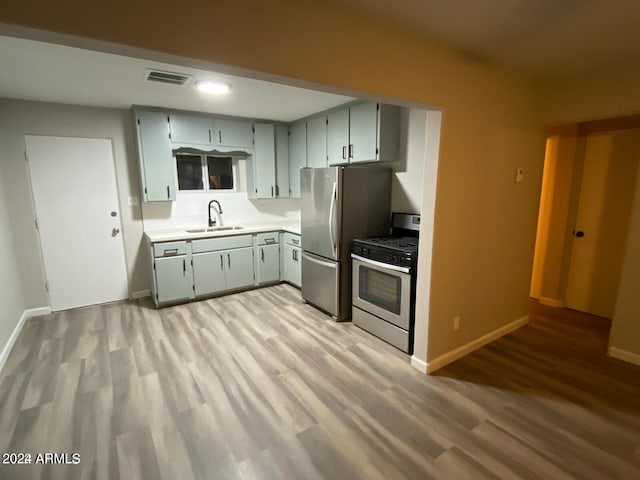 kitchen featuring sink, stainless steel appliances, light hardwood / wood-style flooring, and gray cabinetry