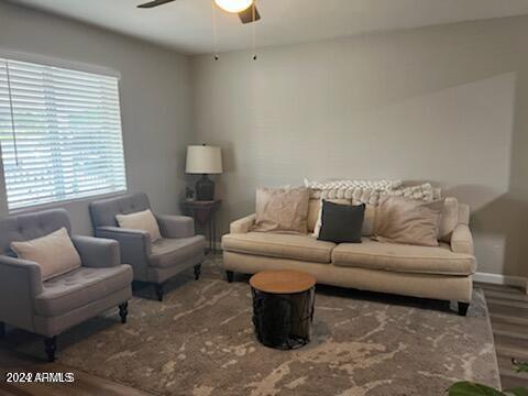 living room featuring wood-type flooring and ceiling fan