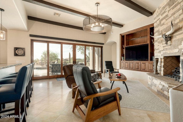 living room with light tile patterned flooring, a fireplace, built in features, beam ceiling, and an inviting chandelier