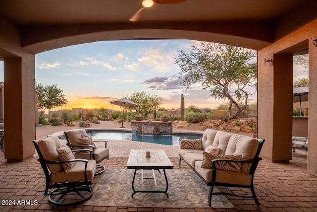 patio terrace at dusk featuring an outdoor living space and pool water feature