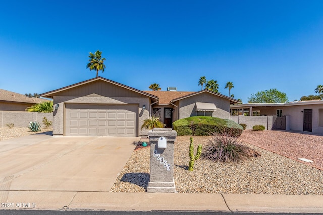 single story home featuring concrete driveway, an attached garage, fence, and stucco siding