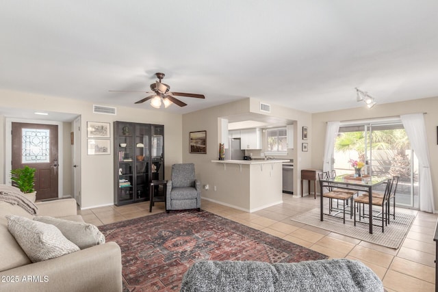 living room with light tile patterned floors, baseboards, visible vents, and ceiling fan