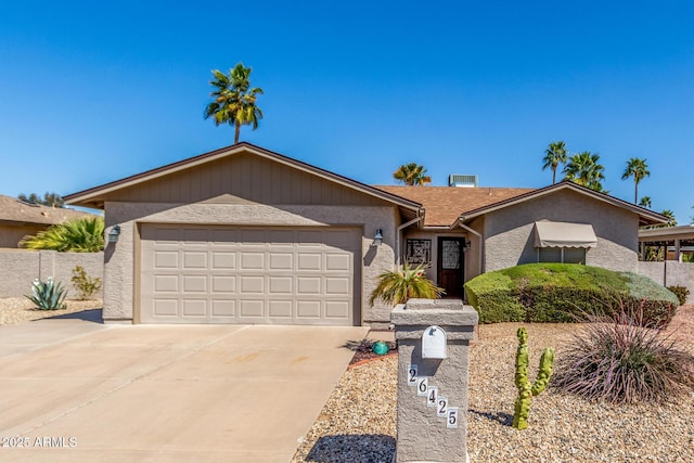 single story home featuring stucco siding, concrete driveway, a garage, and fence