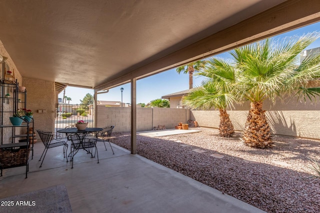 view of patio featuring outdoor dining area and fence