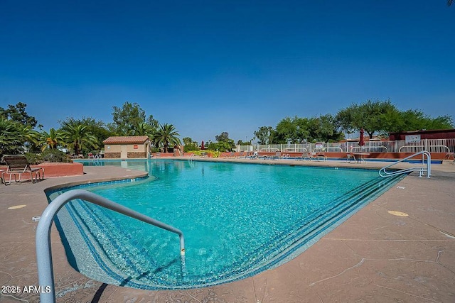 pool with a patio and fence