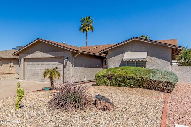 view of front of house with stucco siding, an attached garage, and concrete driveway