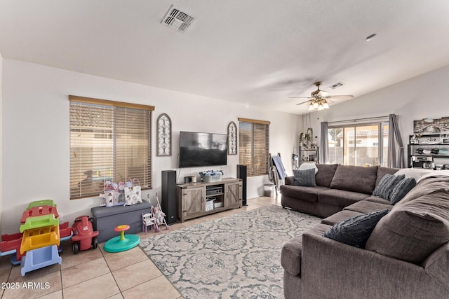 living room with lofted ceiling, light tile patterned floors, and ceiling fan