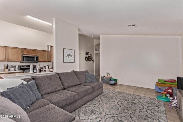 living room with high vaulted ceiling and light tile patterned floors