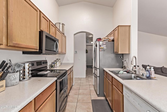 kitchen featuring vaulted ceiling, appliances with stainless steel finishes, sink, and light tile patterned floors