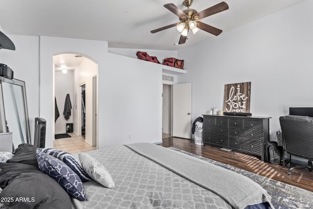 bedroom with ceiling fan, lofted ceiling, and light wood-type flooring