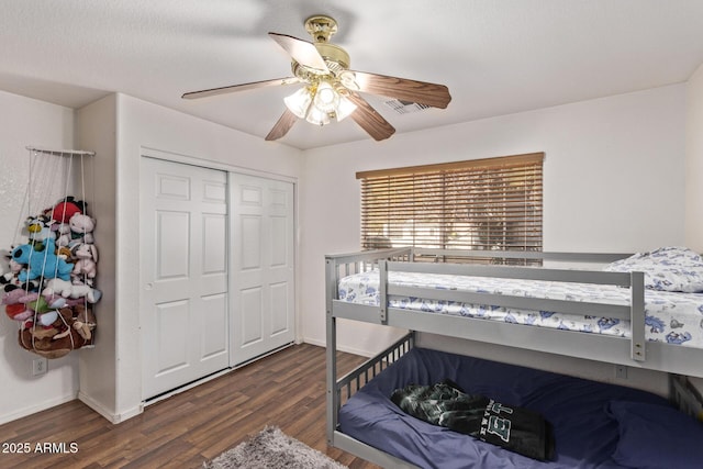 bedroom featuring a closet, dark hardwood / wood-style floors, and ceiling fan