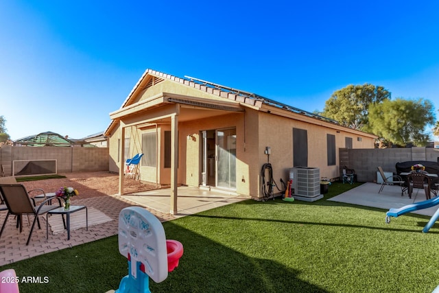 rear view of house featuring a yard, central AC, and a patio area