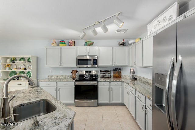 864 S 223rd Ln, Buckeye, AZ 85326 - kitchen with appliances with stainless steel finishes, a sink, light tile patterned floors, white cabinetry, and light stone counters