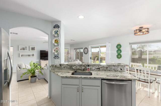 864 S 223rd Ln, Buckeye, AZ 85326 - kitchen with stainless steel appliances, a sink, light tile patterned floors, arched walkways, and recessed lighting