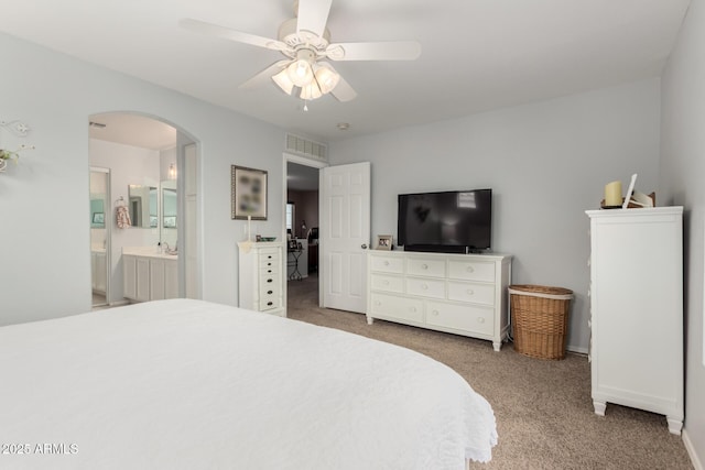 864 S 223rd Ln, Buckeye, AZ 85326 - carpeted bedroom featuring arched walkways, a ceiling fan, connected bathroom, and baseboards