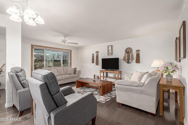 living room with dark wood-type flooring and ceiling fan with notable chandelier