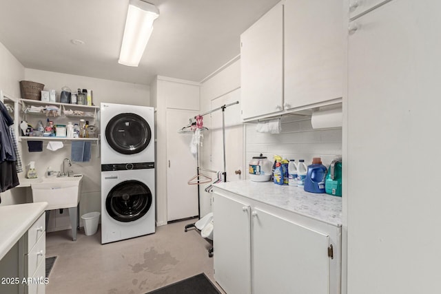 laundry room with cabinets and stacked washer and clothes dryer