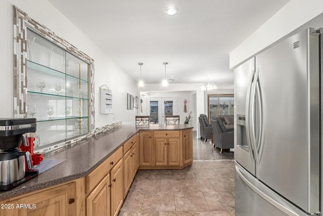 kitchen with french doors, light brown cabinetry, decorative light fixtures, stainless steel fridge with ice dispenser, and kitchen peninsula