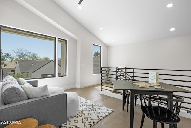 living room featuring lofted ceiling and light hardwood / wood-style flooring