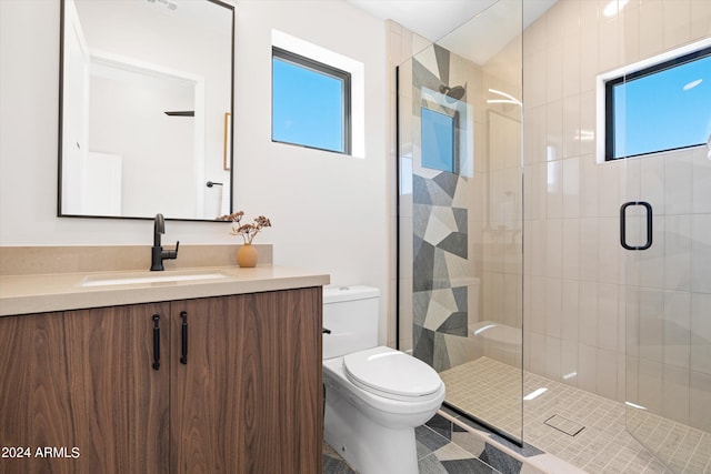 bathroom featuring tile patterned flooring, a shower with door, vanity, and toilet