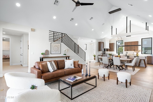 living room with high vaulted ceiling, light hardwood / wood-style flooring, and ceiling fan