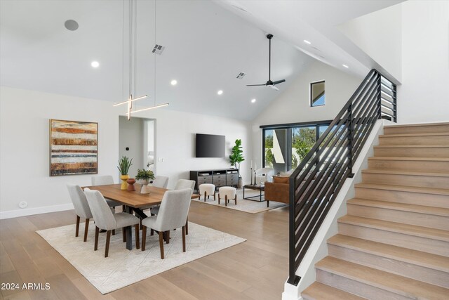 dining area featuring light hardwood / wood-style flooring, high vaulted ceiling, and ceiling fan