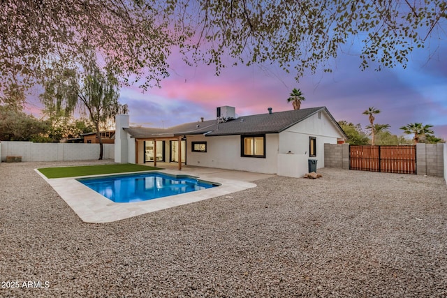 2905 W Campo Bello Dr, Phoenix, AZ 85053 - back of property at dusk featuring a fenced in pool, a gate, a fenced backyard, and a patio area