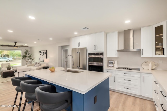 2905 W Campo Bello Dr, Phoenix, AZ 85053 - kitchen featuring appliances with stainless steel finishes, a sink, wall chimney exhaust hood, open floor plan, and visible vents