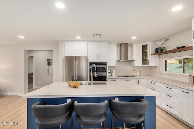 2905 W Campo Bello Dr, Phoenix, AZ 85053 - kitchen with recessed lighting, light wood-style flooring, wall chimney exhaust hood, and appliances with stainless steel finishes