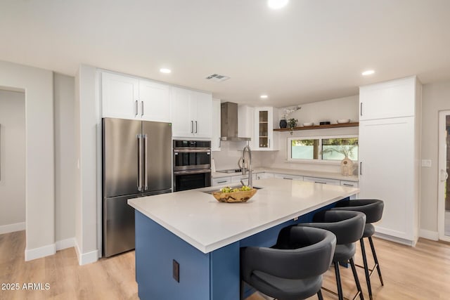 2905 W Campo Bello Dr, Phoenix, AZ 85053 - kitchen featuring visible vents, appliances with stainless steel finishes, white cabinets, and wall chimney range hood