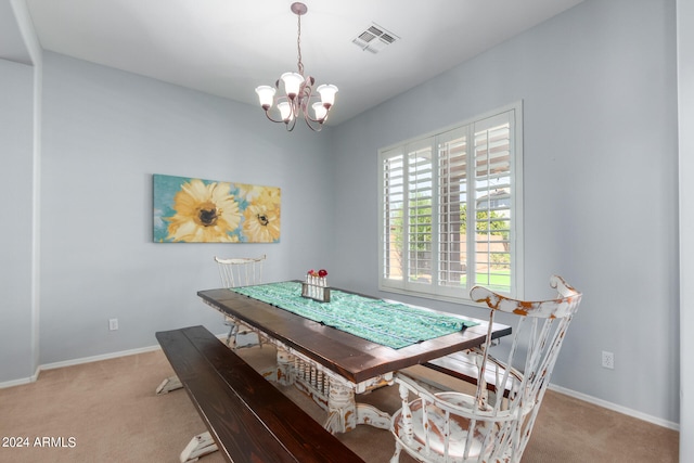 dining space with light colored carpet and a chandelier