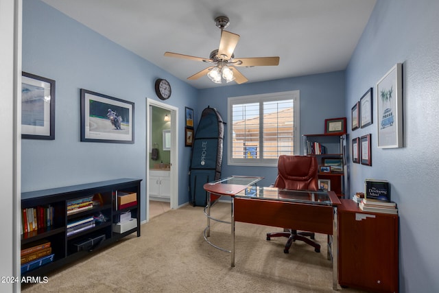 carpeted office space featuring ceiling fan