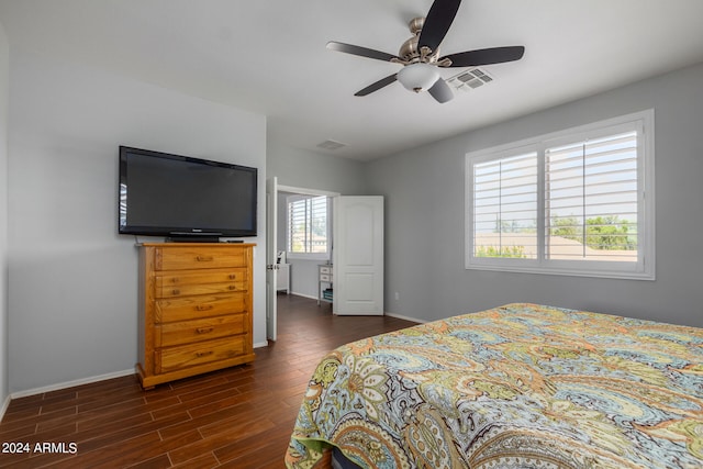 bedroom with dark wood-type flooring, multiple windows, and ceiling fan