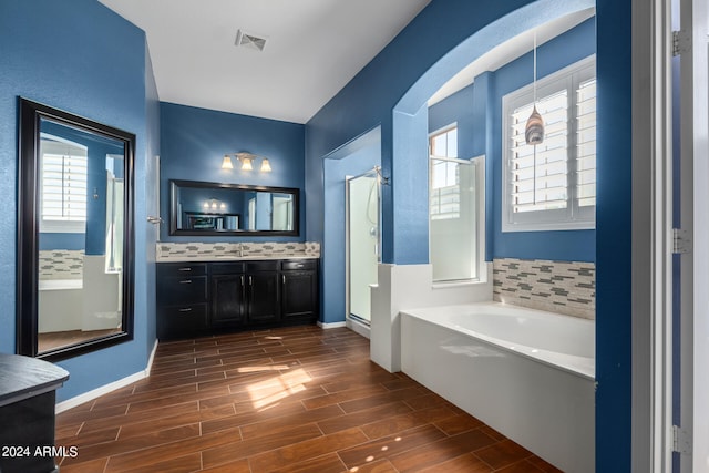 bathroom with independent shower and bath and vanity