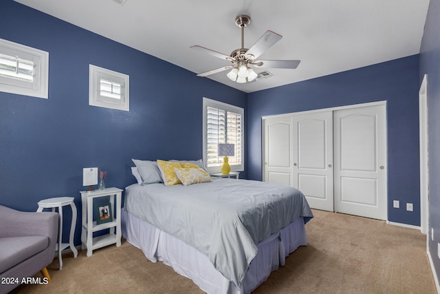 carpeted bedroom featuring ceiling fan and a closet