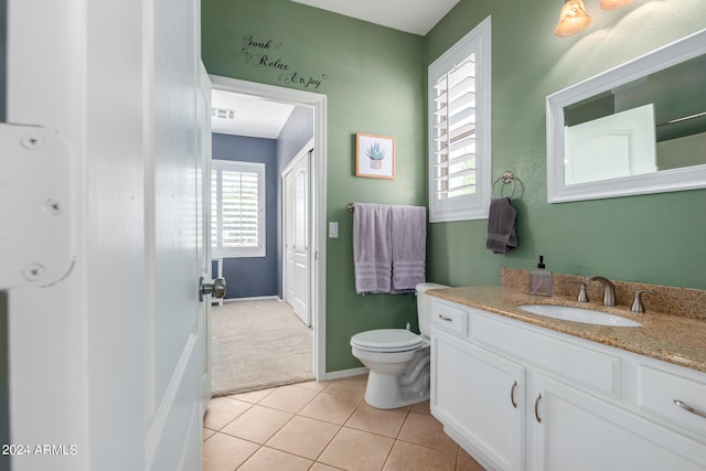 bathroom with toilet, vanity, and tile patterned flooring