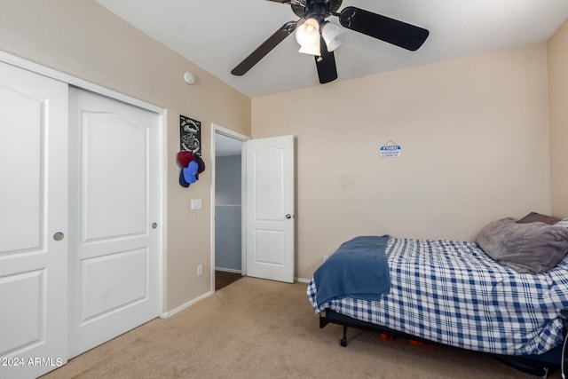 bedroom featuring ceiling fan, light carpet, and a closet