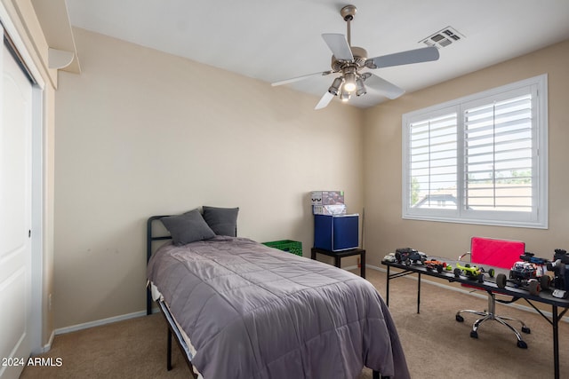 carpeted bedroom featuring ceiling fan and a closet