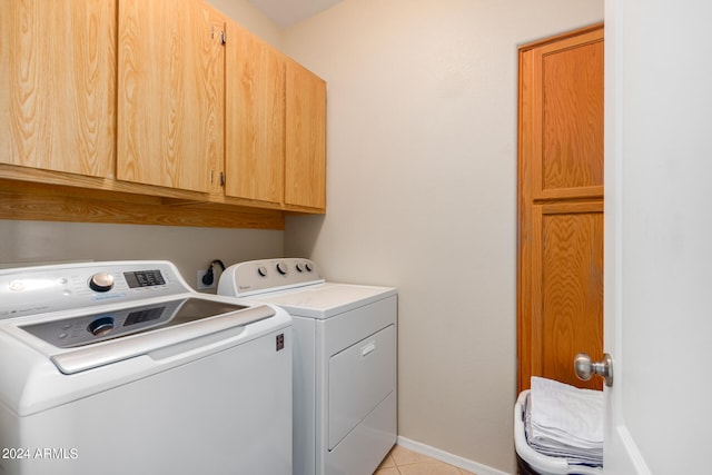 laundry area featuring cabinets, washing machine and clothes dryer, and light tile patterned flooring