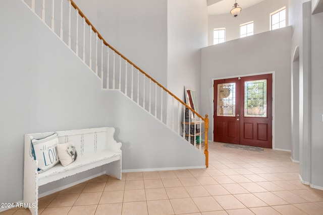 tiled entrance foyer with french doors and a towering ceiling