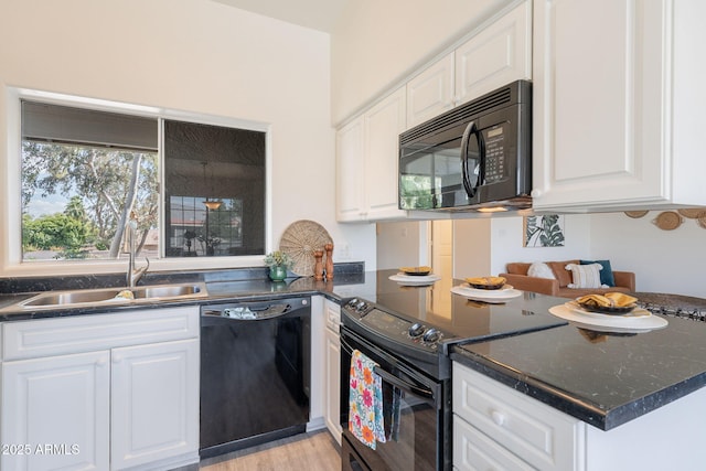 kitchen featuring a sink, white cabinets, black appliances, and a peninsula