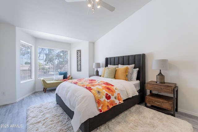 bedroom featuring baseboards, a ceiling fan, wood finished floors, and vaulted ceiling