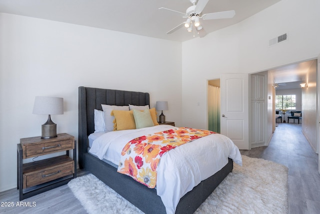 bedroom with a ceiling fan, visible vents, and wood finished floors