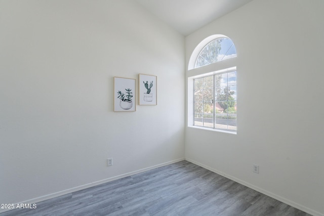spare room featuring baseboards and wood finished floors